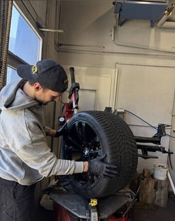 Mechaniker zieht einen Reifen auf der Montiermaschine auf