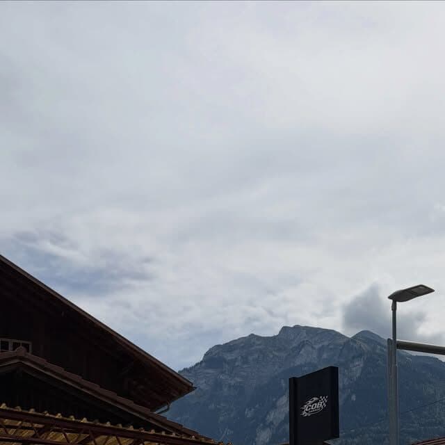 Die COB Garage von aussen, mit Firmenschild und Bergen im Hintergrund